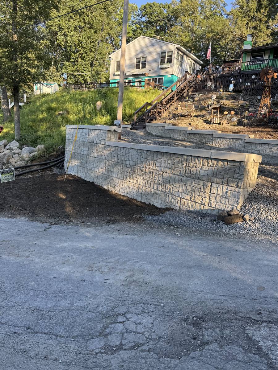 Large segmental block retaining wall with capstones built into a sloped yard