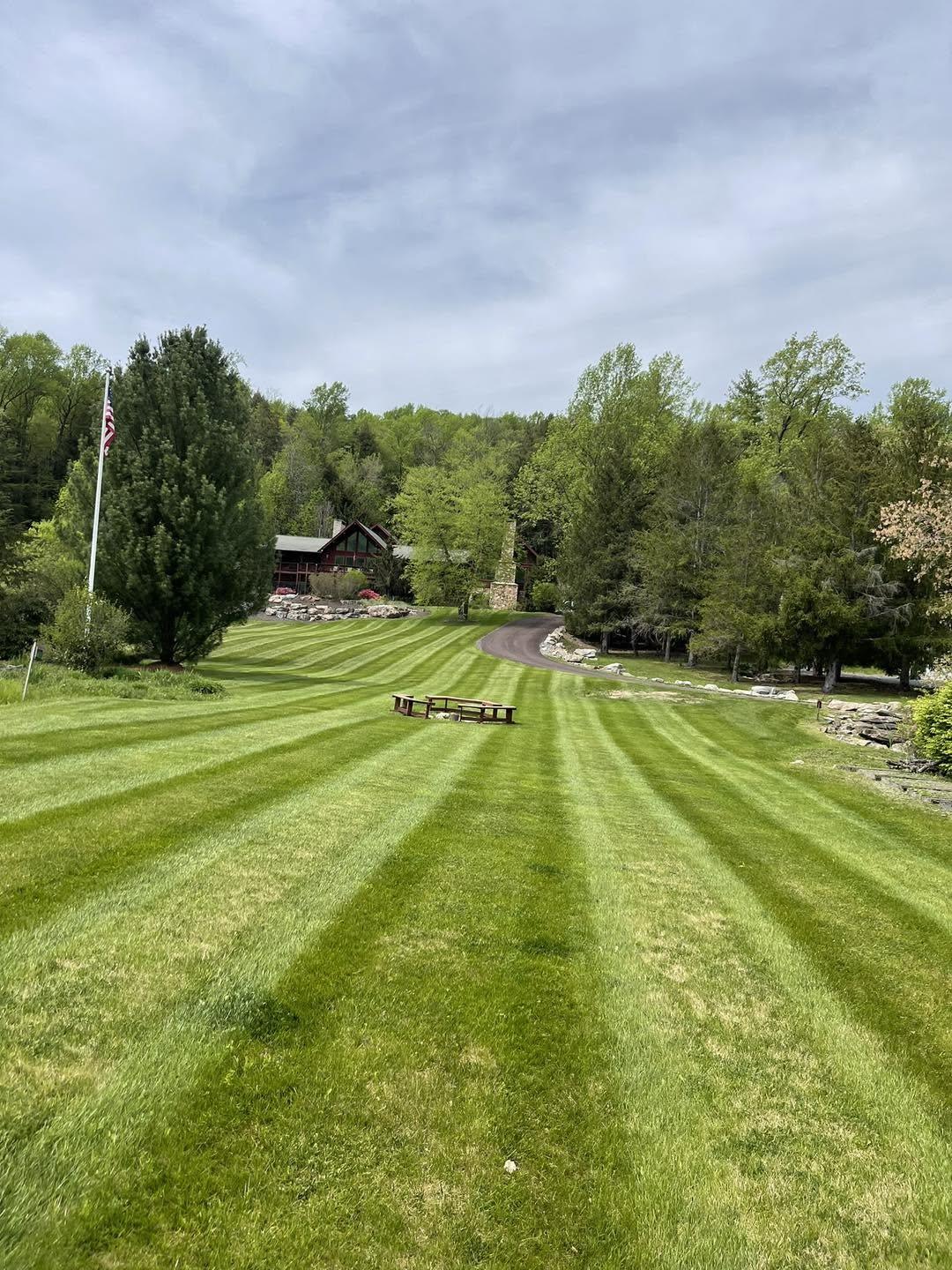Freshly landscaped yard with a striped lawn and mulched bed in front of a home